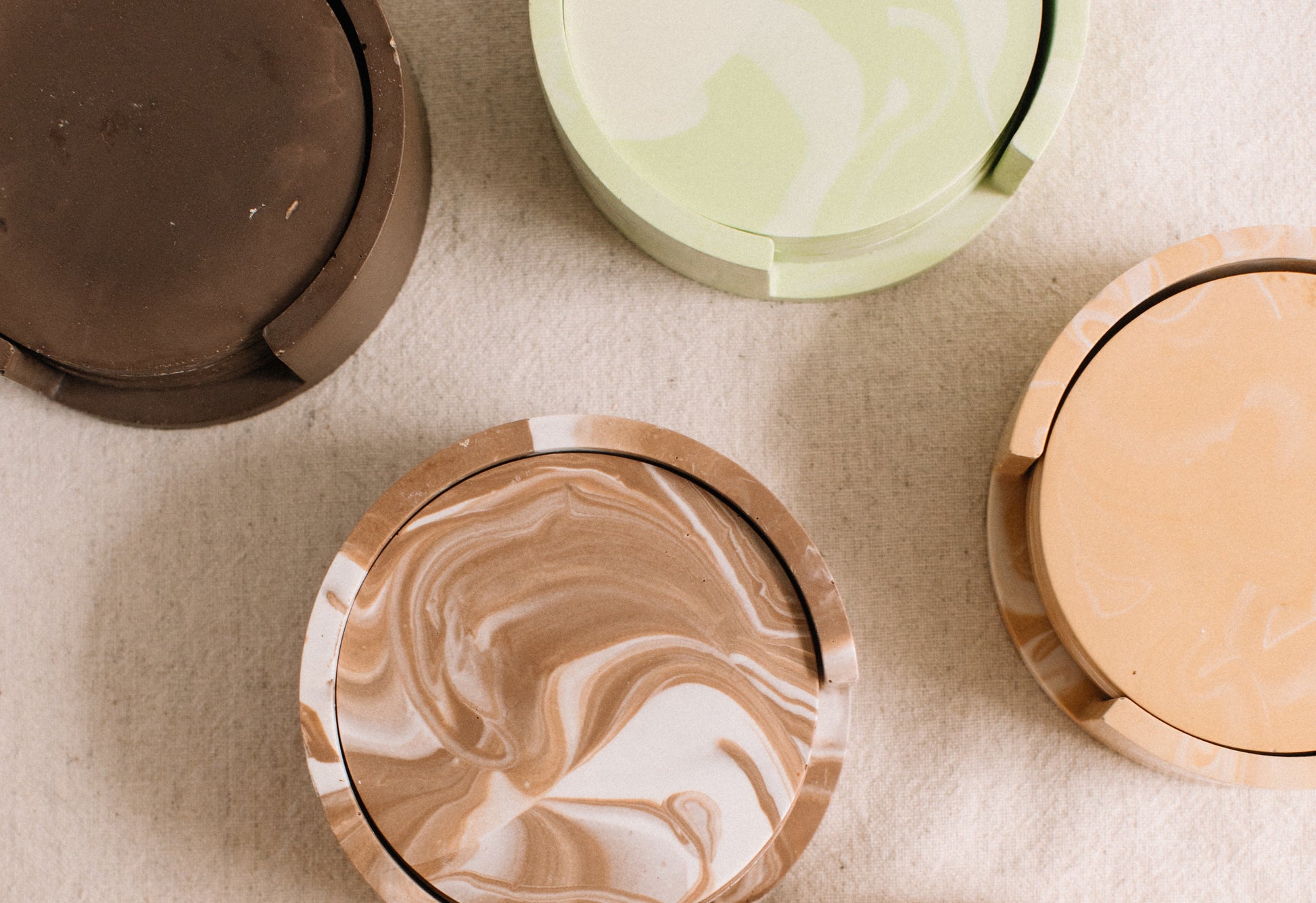 Marbled drink coasters in various colors on a textured surface