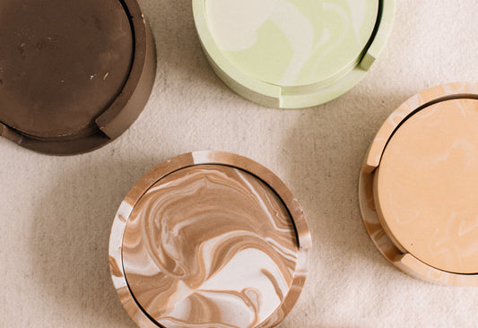 Marbled drink coasters in various colors on a textured surface